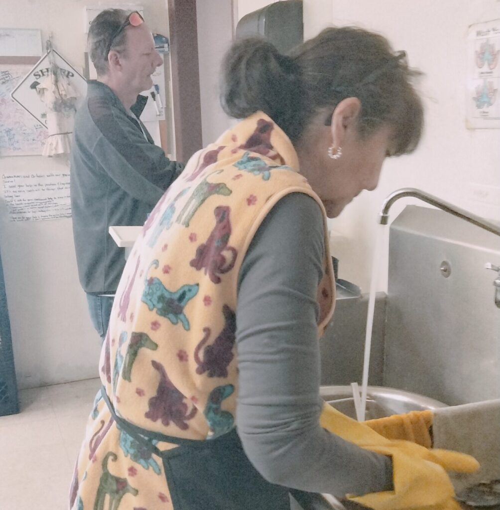 A woman washing dishes at a soup kitchen